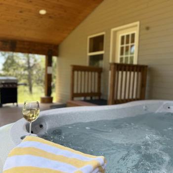 Hot tub and grill are conveniently located outside in the back of the cabin.