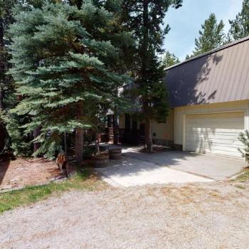 This cabin is nestled in the towering pine trees.
