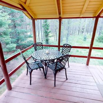 Outside is a deck with a table to enjoy the scenery outside.