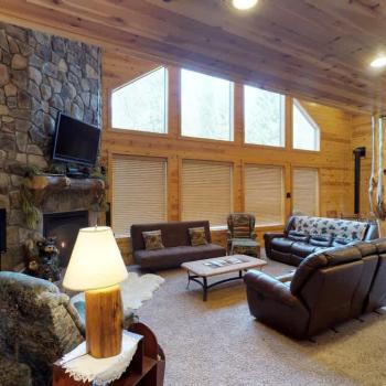 The living room has seating, a wood fireplace, and a television for entertainment. Wood is not provided be sure to bring your own.
