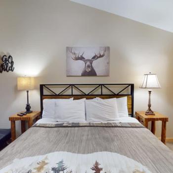 First bedroom with a king size bed, seating, and closet space.