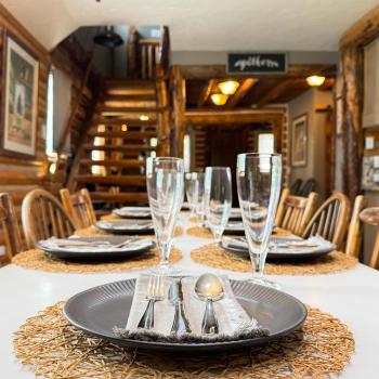 Host memorable family dinners at the large rustic dining table, perfectly set with beautiful tableware right next to the log staircase.
