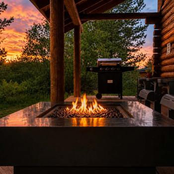 Experience unforgettable evenings on the covered deck, where you can watch a breathtaking golden sunset over the trees while staying cozy by the warm propane gas fire pit table.
