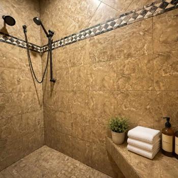 Step into the luxurious master ensuite shower, beautifully designed with premium tiling, dual shower heads, and built-in bench seating.