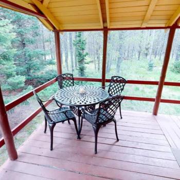 Outside is a deck with a table to enjoy the scenery outside.