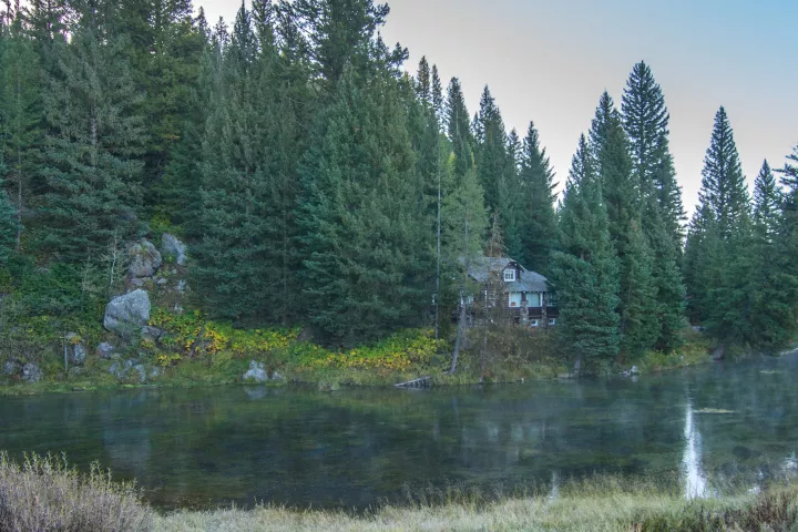 The clear headwater pool at Big Springs, with the Johnny Sack Cabin behind