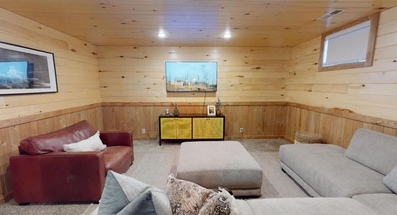 Downstairs living room with seating and tv for entertainment.