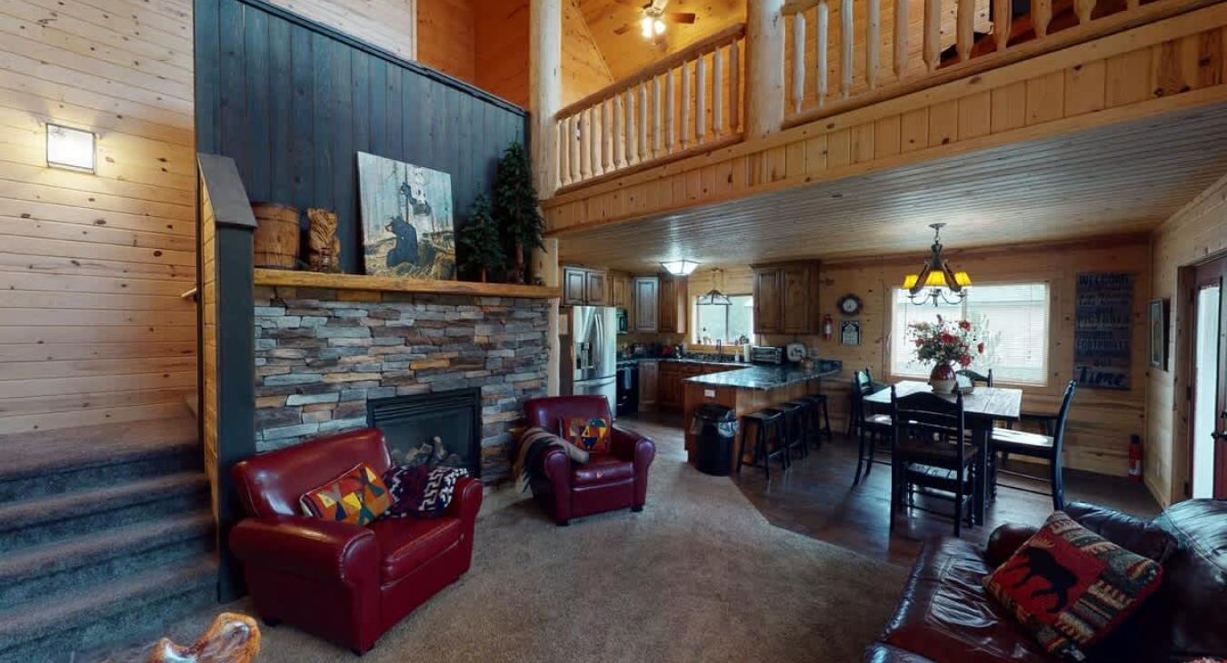 Open living room with seating and a fireplace.