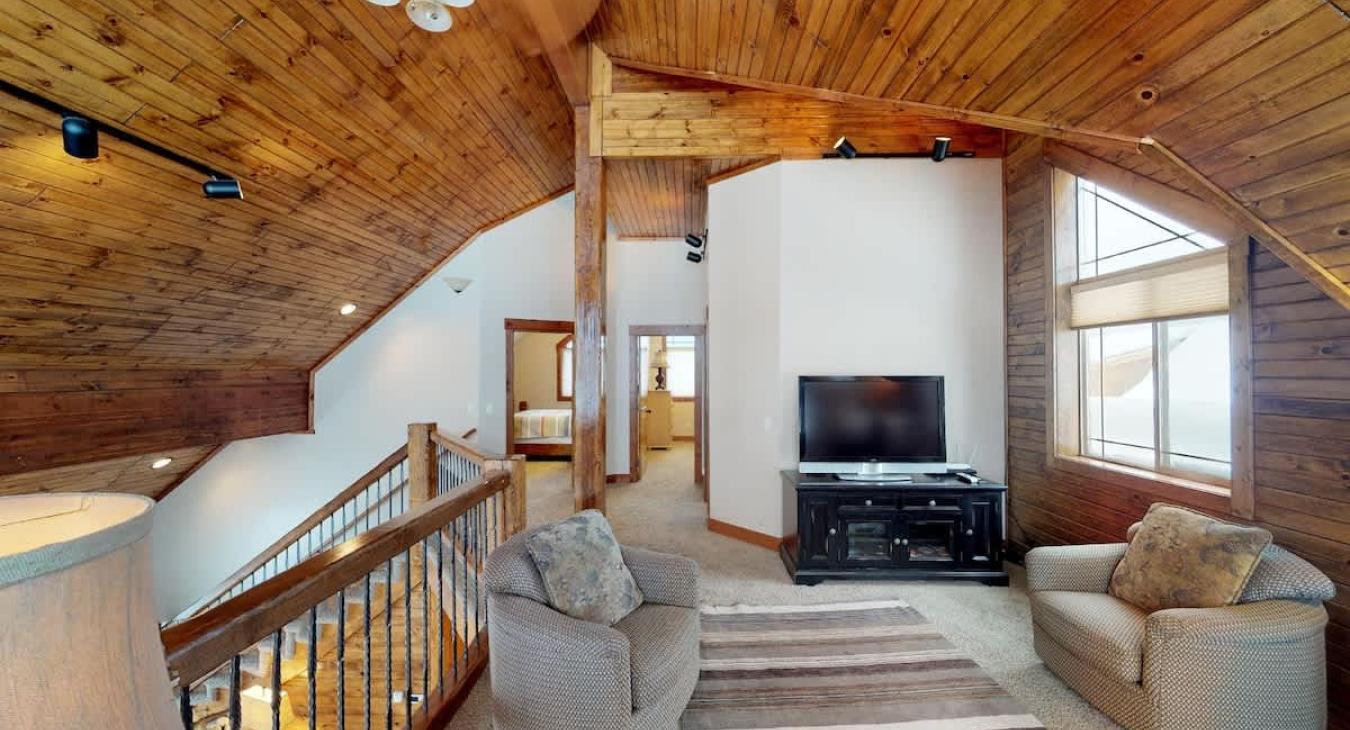 Upstairs there is a loft area with large windows and seating.