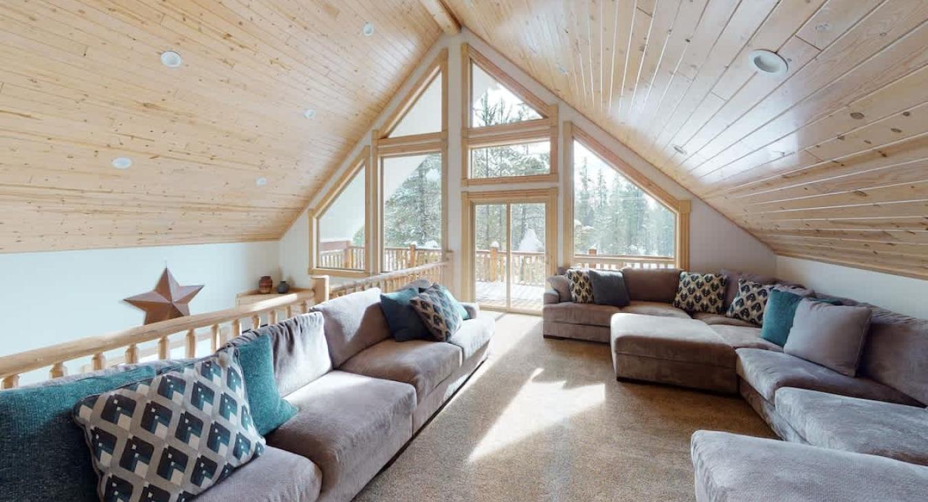 Upstairs loft with sofas and and lots of natural light from the windows.
