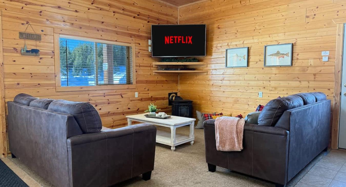 Picture a warm, open-concept living room with a cabin vibe—wood tones, soft textures, and a layout that encourages conversation and connection.