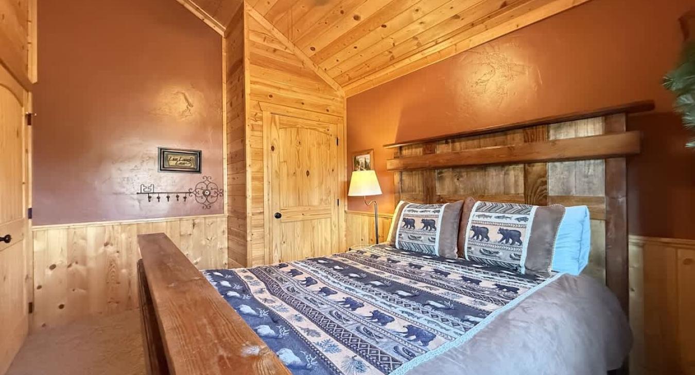 A bedside table and lamp is located near the bed.