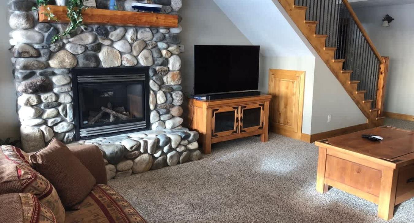 Basement living room with tv and fireplace.