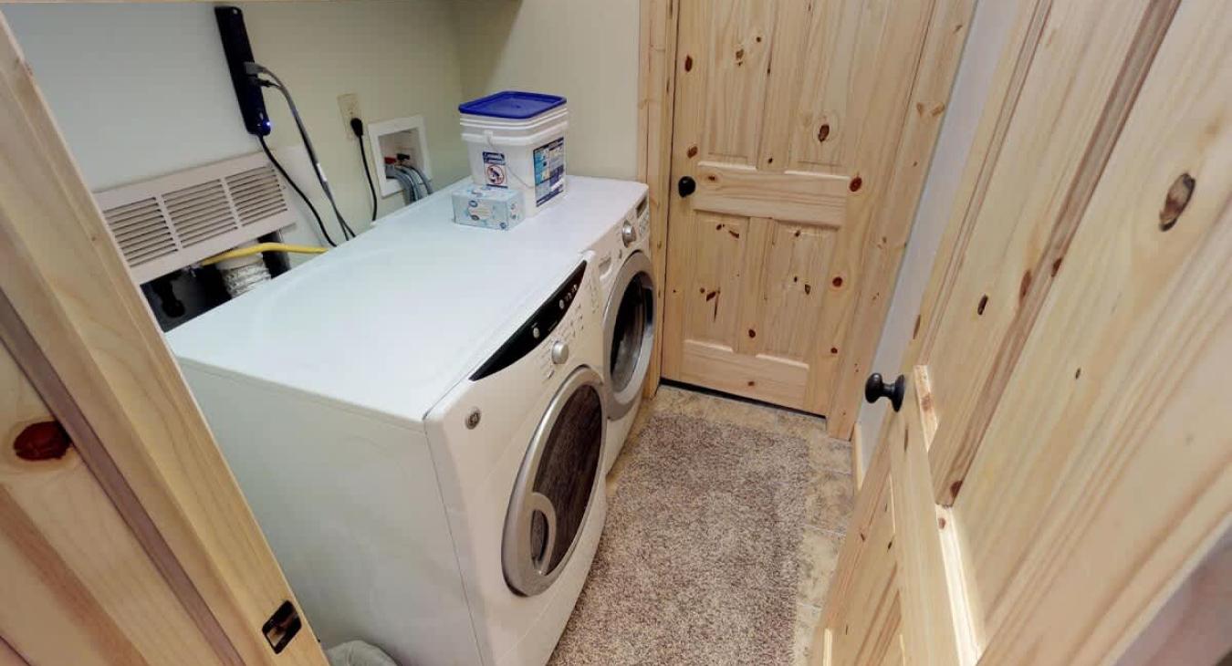 Basement closet with full size washer and dryer. Laundry soap powder is provided.
