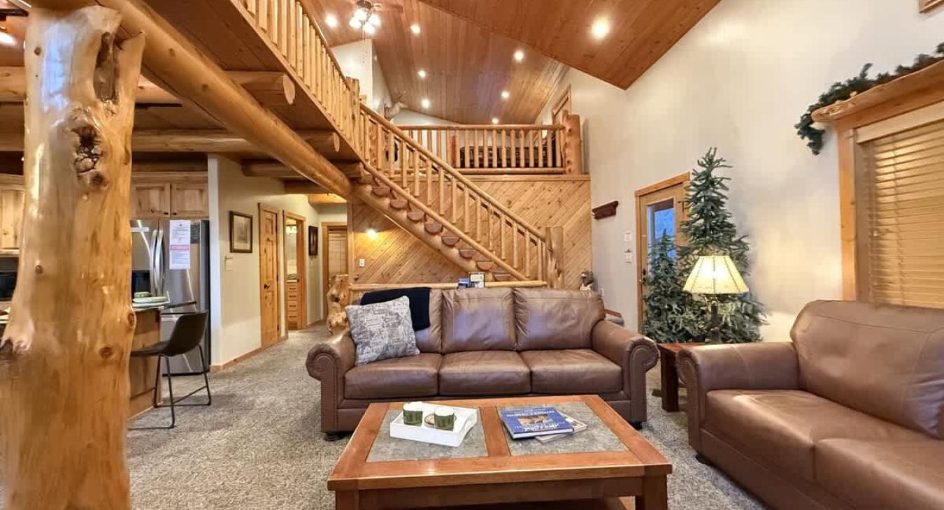 Main level living room with seating and a fireplace for everyone to enjoy.