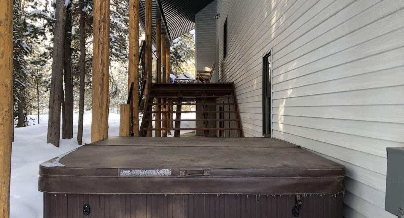 Hot tub is located on the backside of the cabin just down the steps from the wrap around porch.