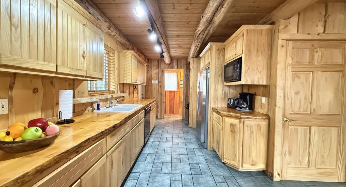 Large kitchen equipped with appliances, pots and pans, dishes, silverware, and basic cooking essentials.