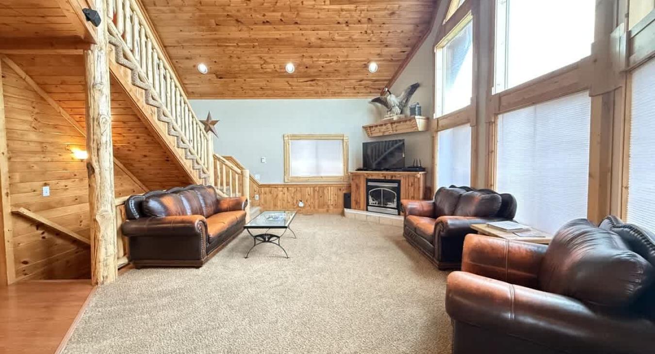 Big open living area with seating, tv for entertainment, and a fireplace.