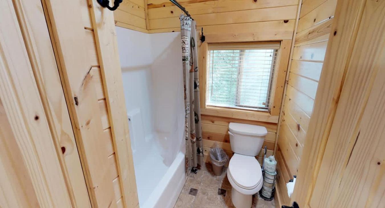 Equipped with a shower/tub combo, toilet, and double sink vanity.