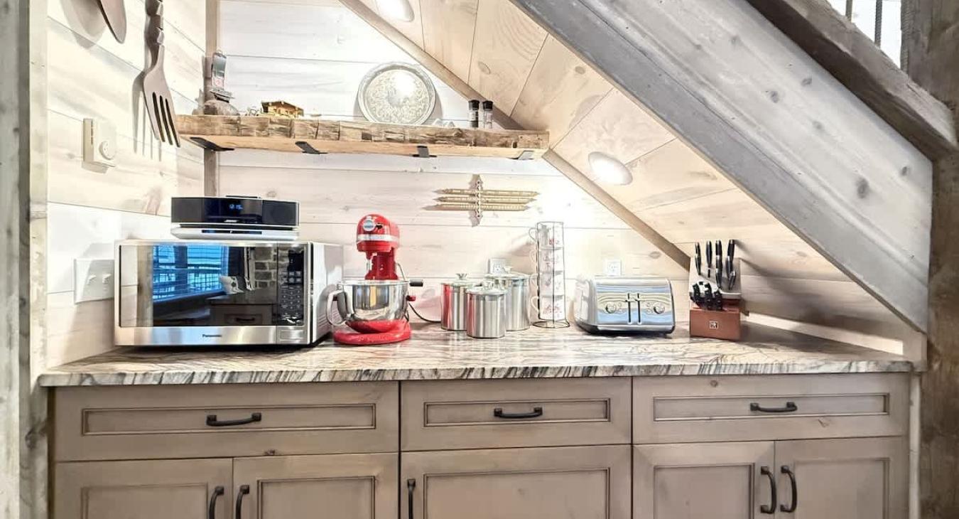 Kitchen rear counter space with microwave and kitchenaid mixer.