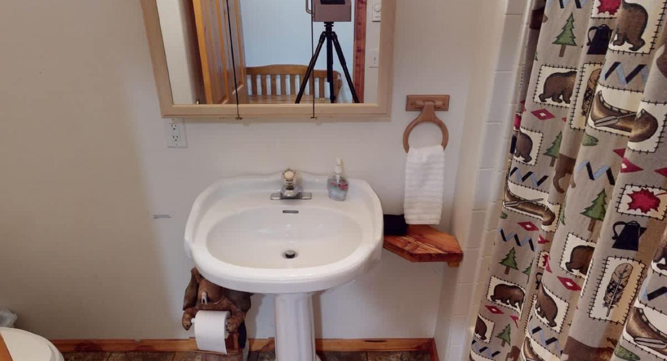 Shared bathroom on the main level with shower tub combo, toilet, and sink.