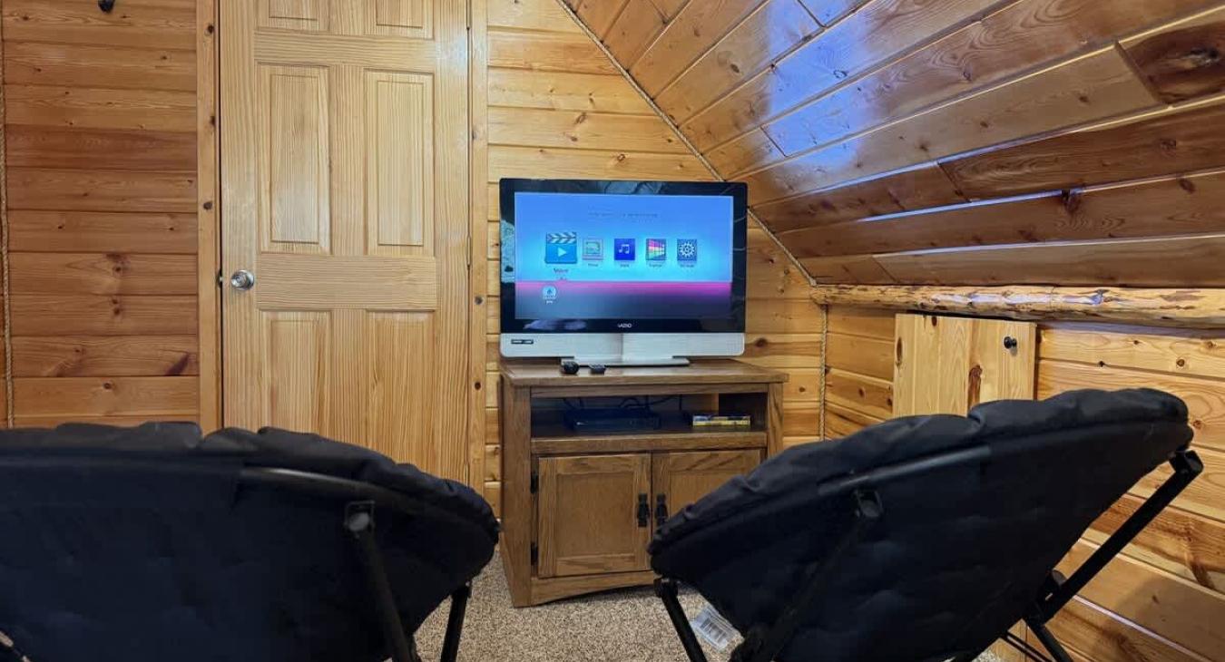 Tv and small chairs upstairs in the loft.