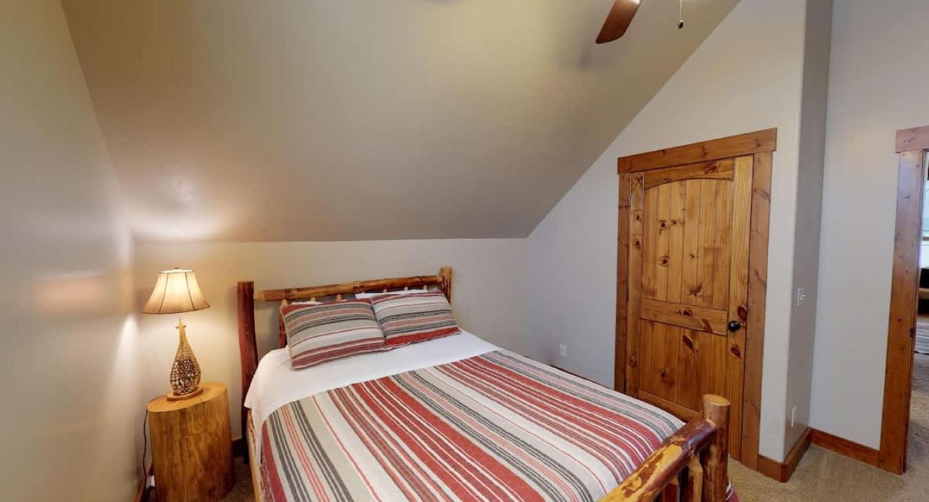 In this bedroom there is a bedside table with a lamp. There is also a closet to store your belongings during your stay.