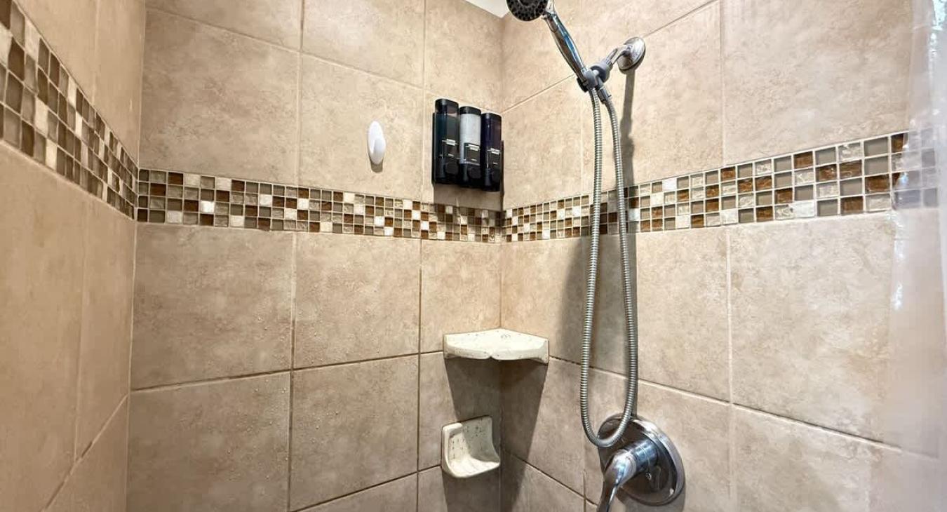 The standing shower is equipped with shampoo, conditioner, and body wash for you to use.