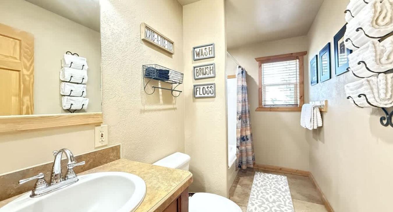 Upstairs bathroom with shower tub combo, toilet, and sink vanity.
