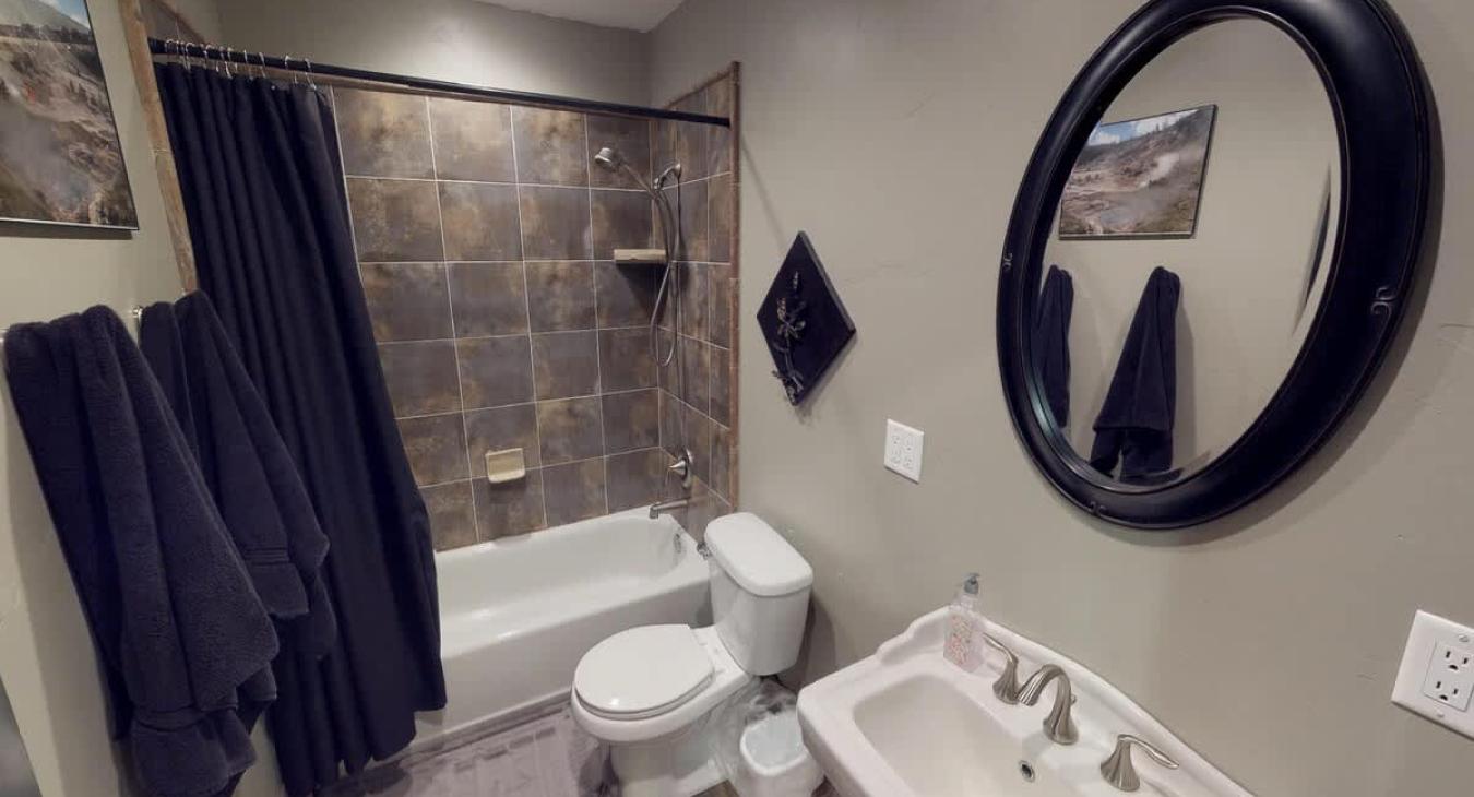 Upstairs bathroom with a shower tub combo, toilet, and sink.