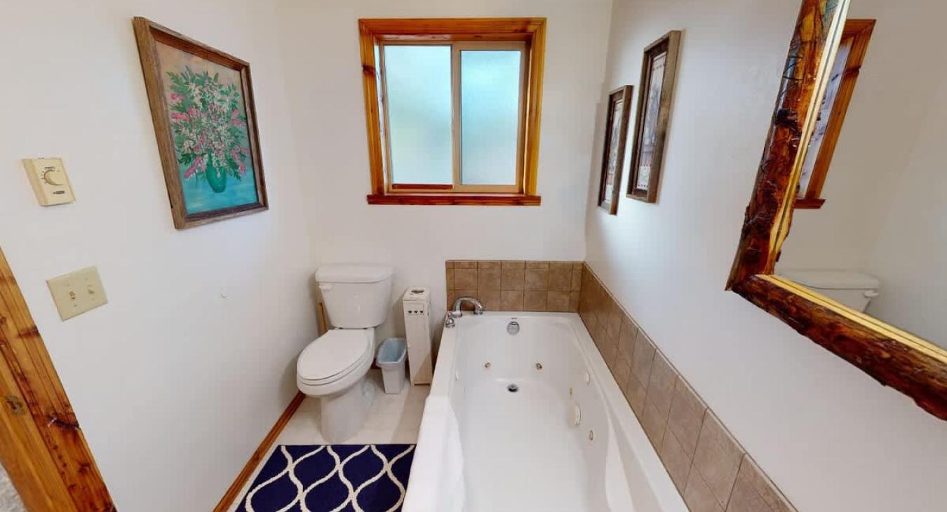 Bathroom is equipped with soaking tub, standing shower, toilet, and sink.