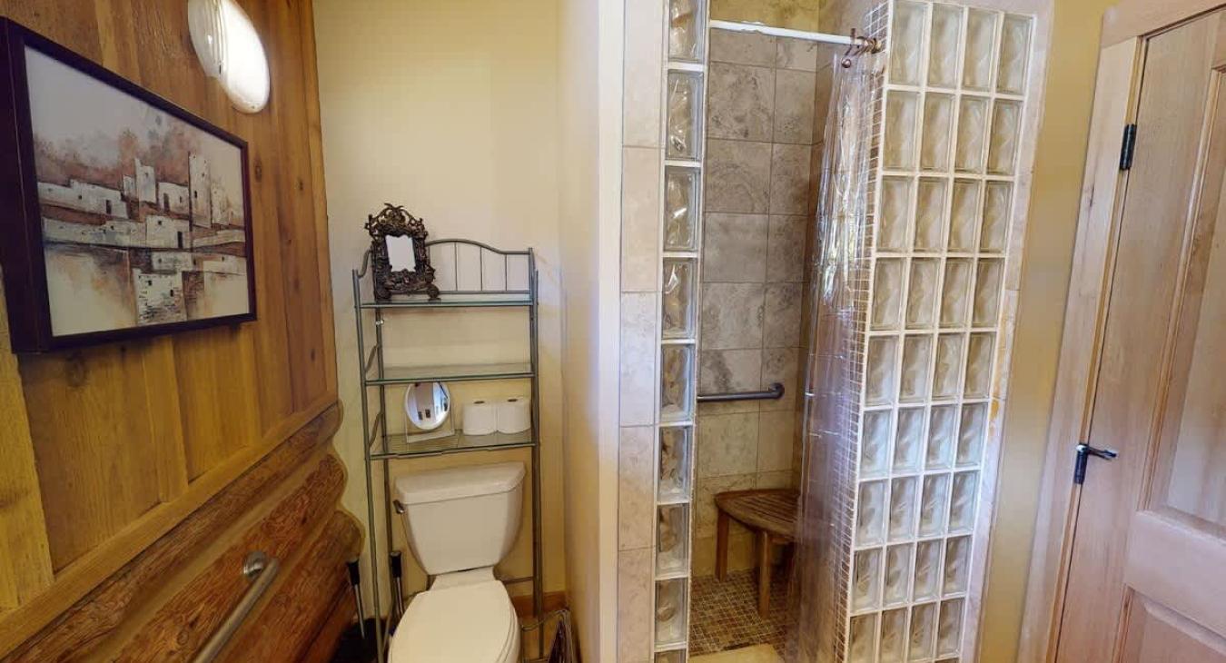 Bathroom #2 located upstairs with a standing shower, toilet, and sink vanity.