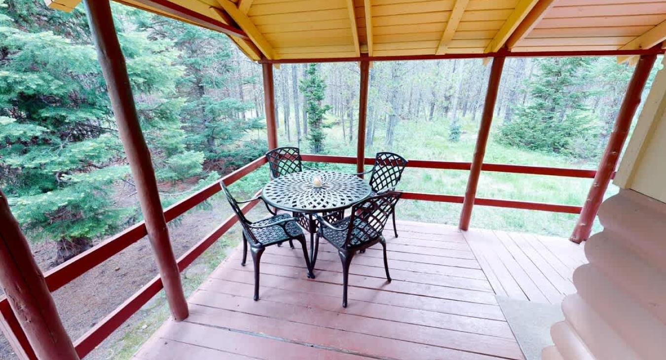 Outside is a deck with a table to enjoy the scenery outside.