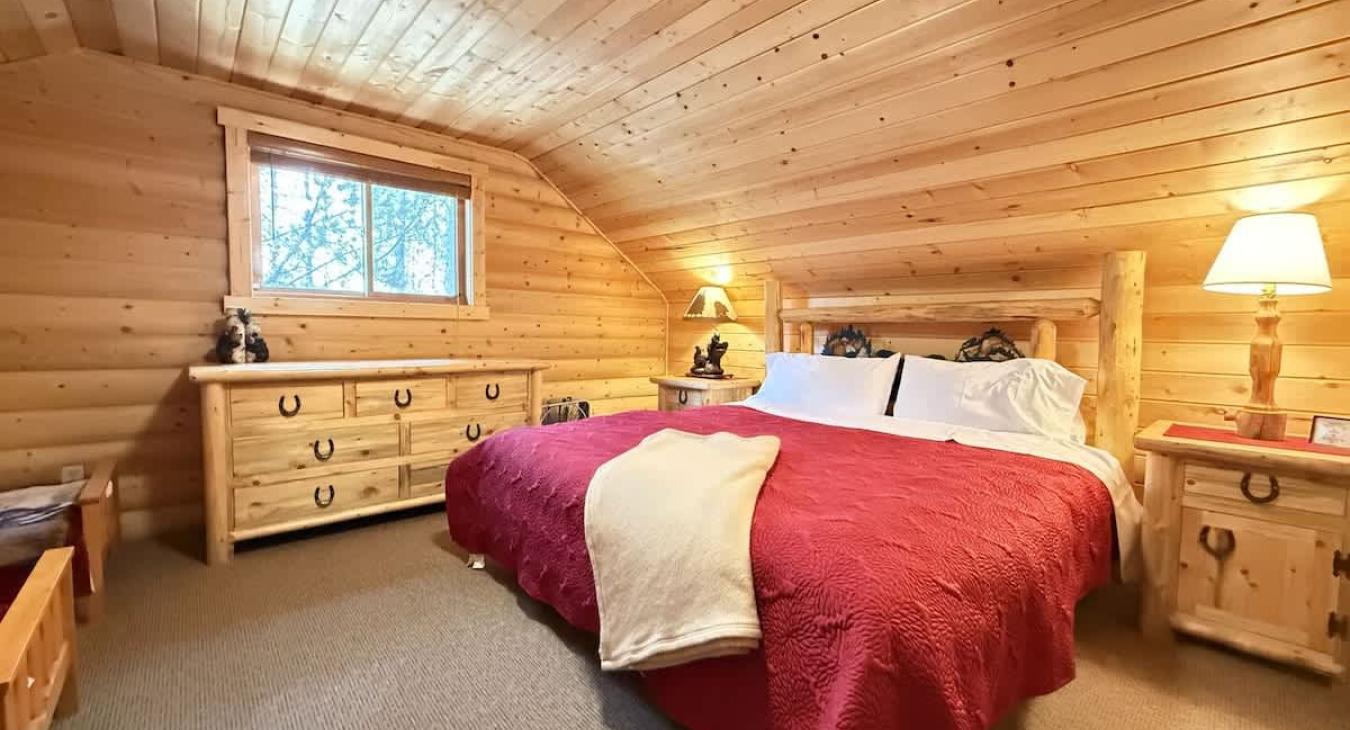 King upstairs bedroom with dresser and small closet.