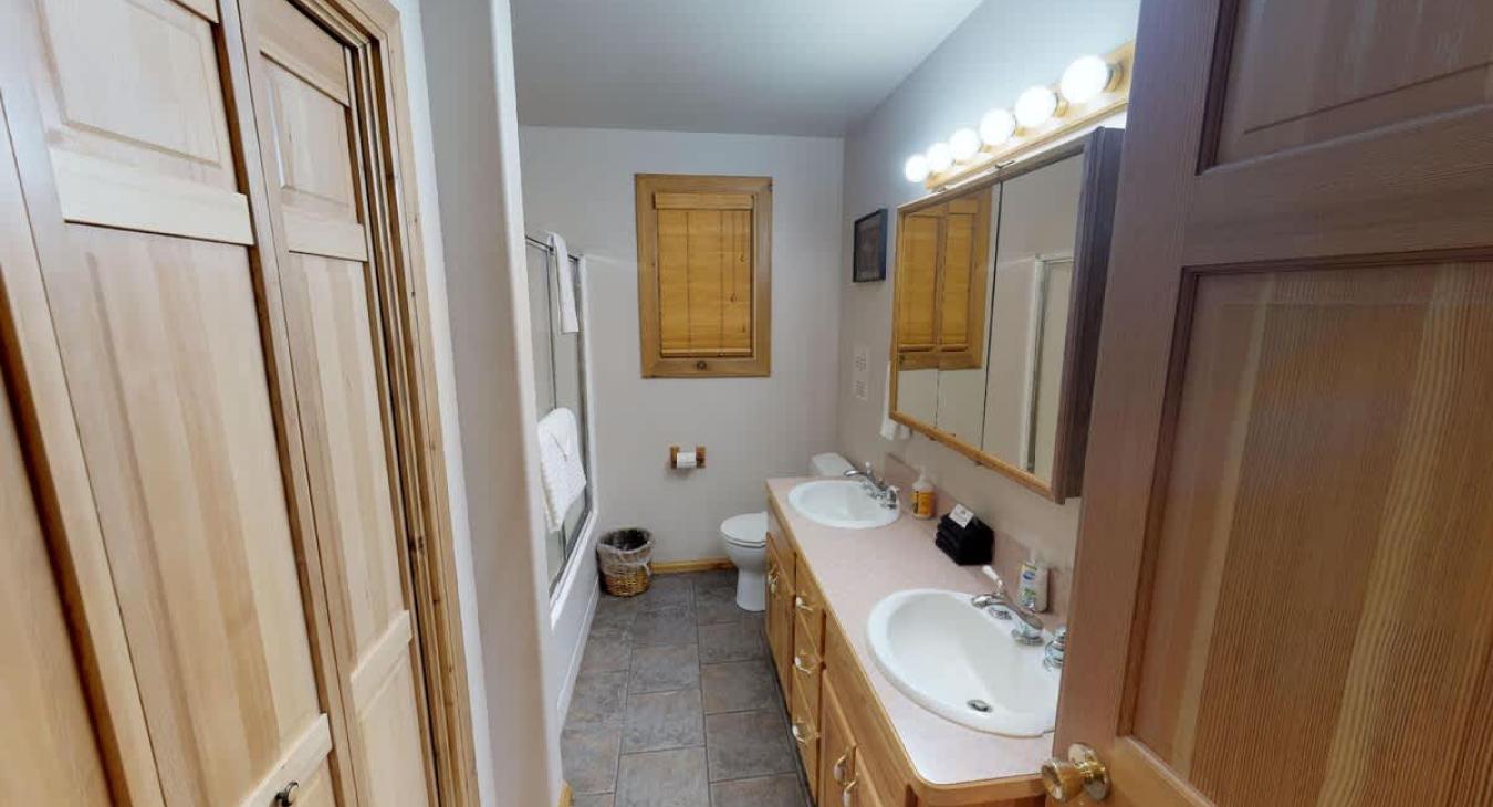 Large bathroom on the main floor features a double sink along with a toilet, and a shower/tub combo.