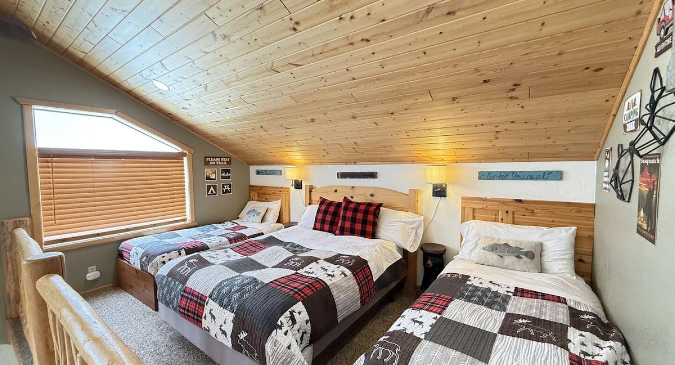 Upstairs loft with a double bed and two twin beds.