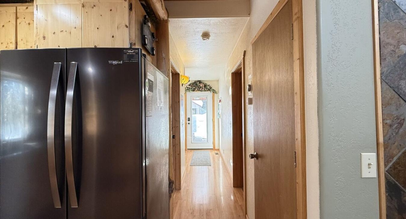 Hallway view of the kitchen and access to the bathroom and laundry room ahead.