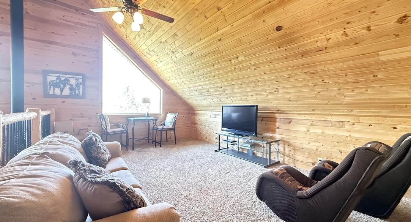 The loft has seating on a couch and a table.