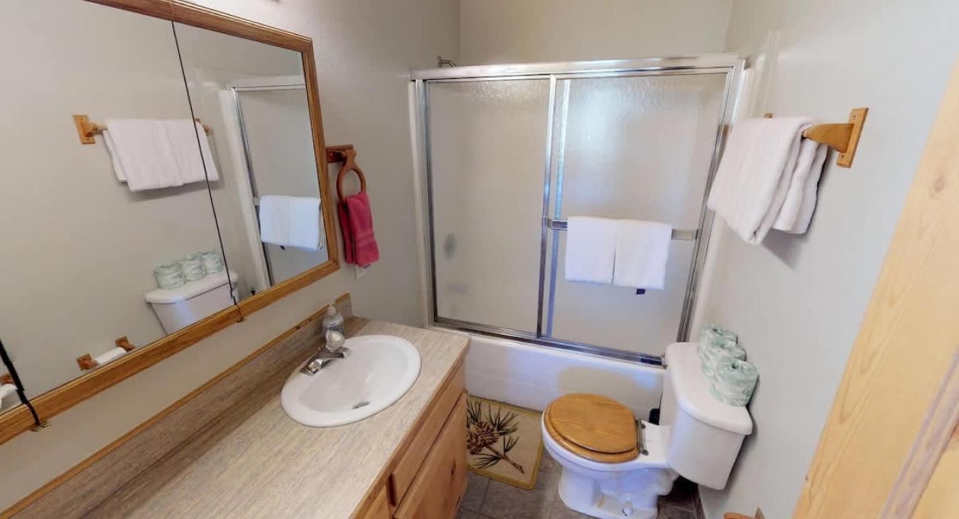 Upstairs shared bathroom with shower/tub, toilet, and sink vanity.