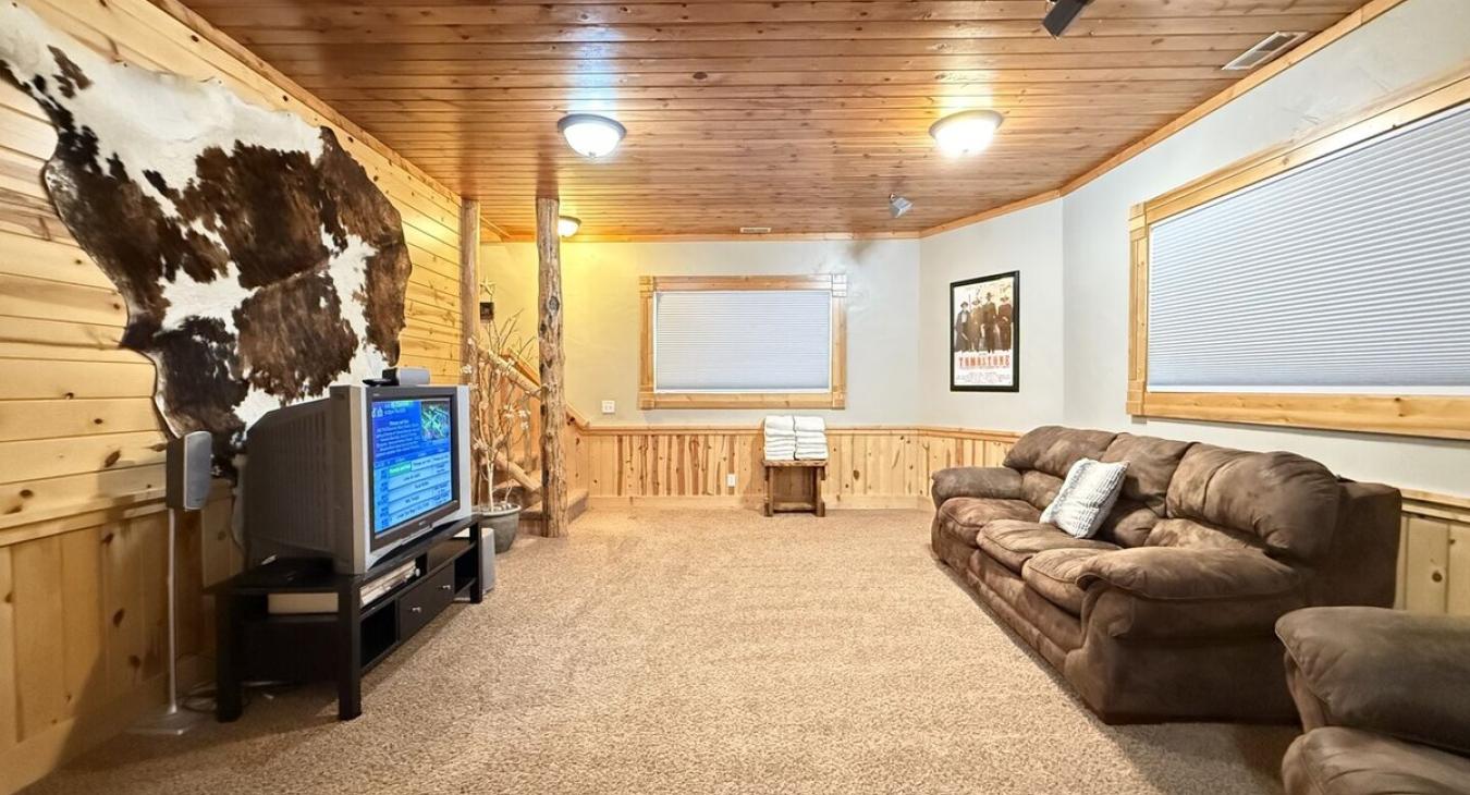 Basement living room with seating and tv for entertainment.