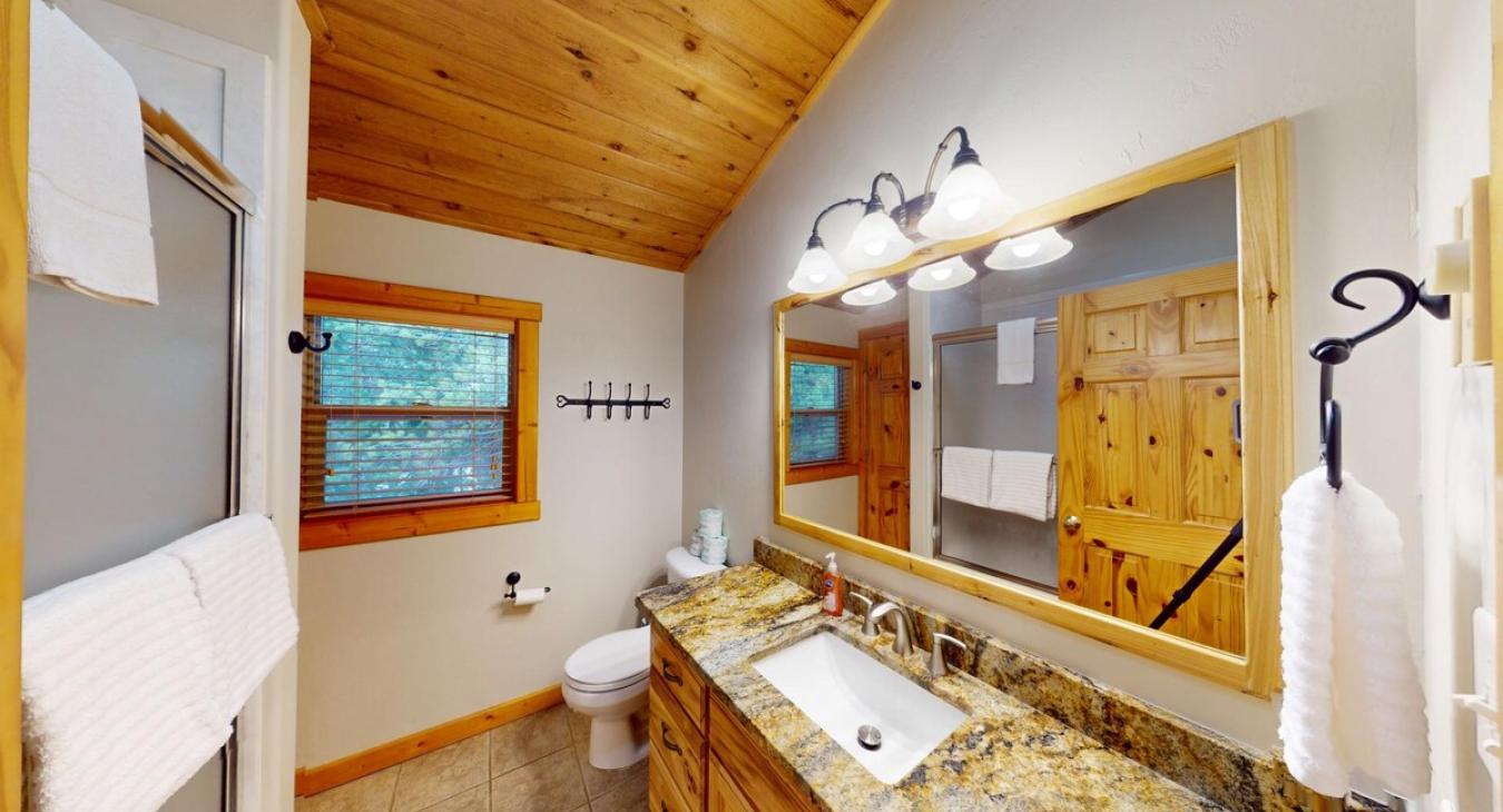 Upstairs bathroom with shower tub combo, toilet, and sink vanity.
