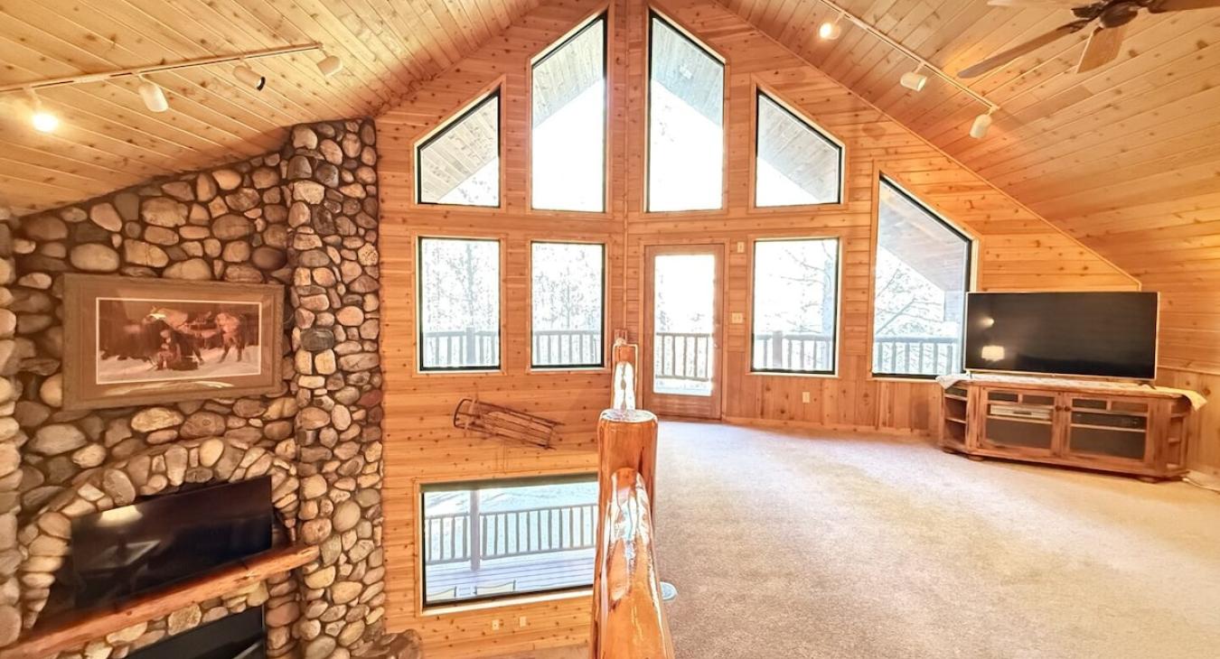 Upstairs loft with tv and seating. Large windows to enjoy the beautiful scenery.