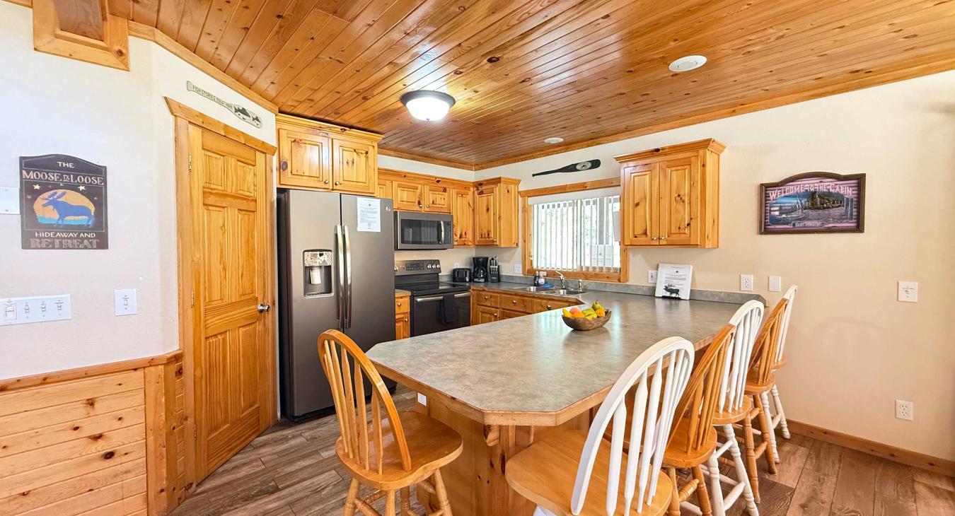 Fully equipped open kitchen with appliances, pots and pans, dishes, utensils, and basic cooking essentials.
