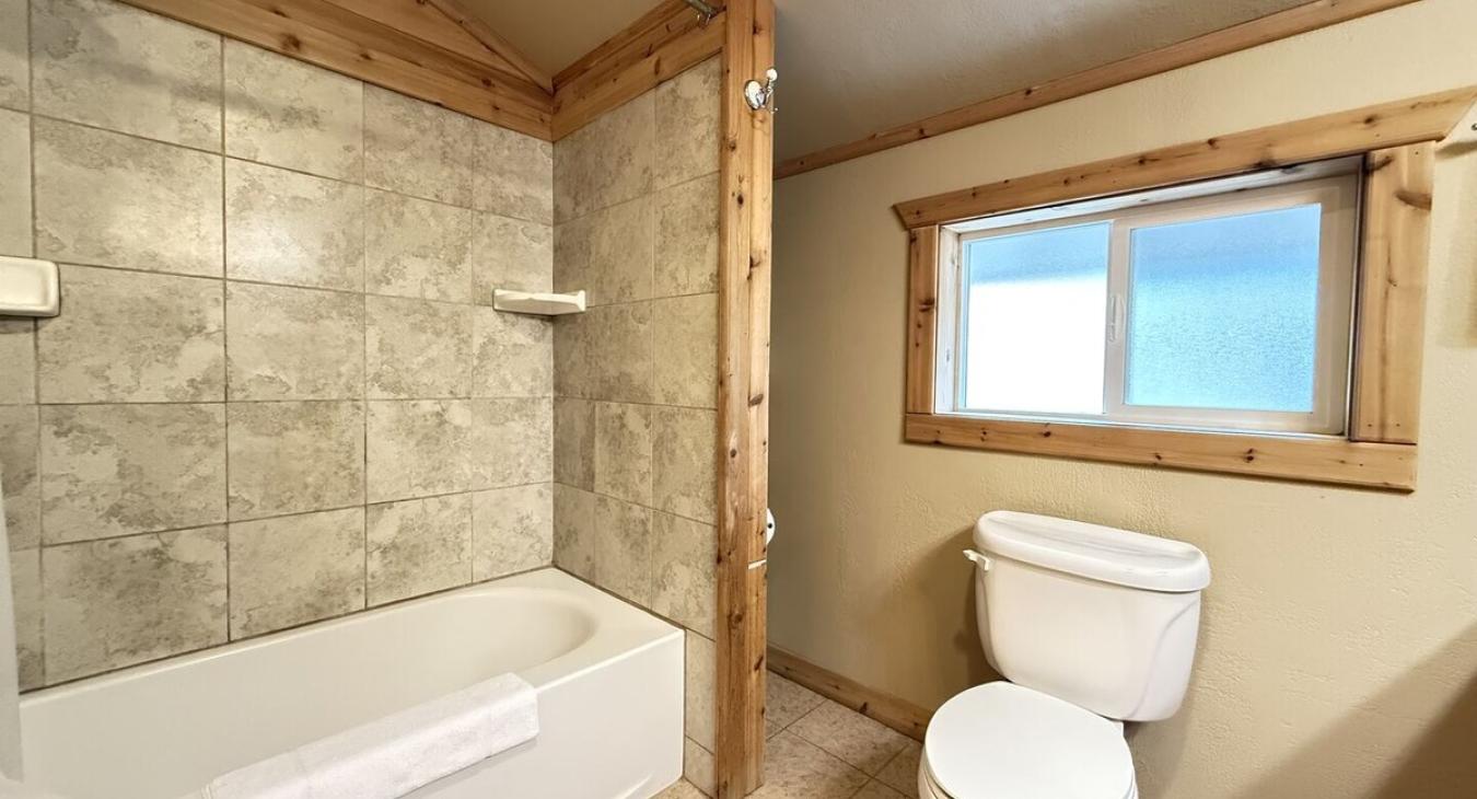 Private master bathroom has a tub and shower combo.