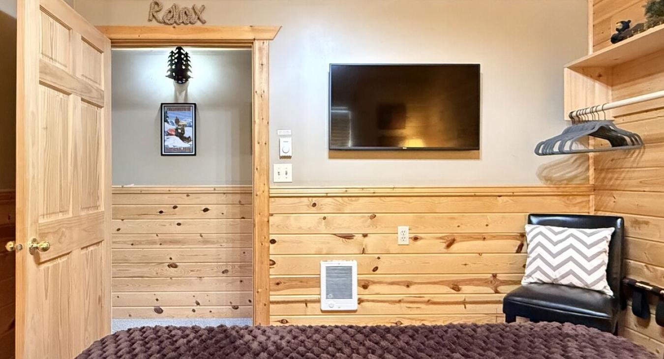 Across from the bed is a flat-screen TV—simple, unobtrusive, ready for late-night movies or quiet mornings.