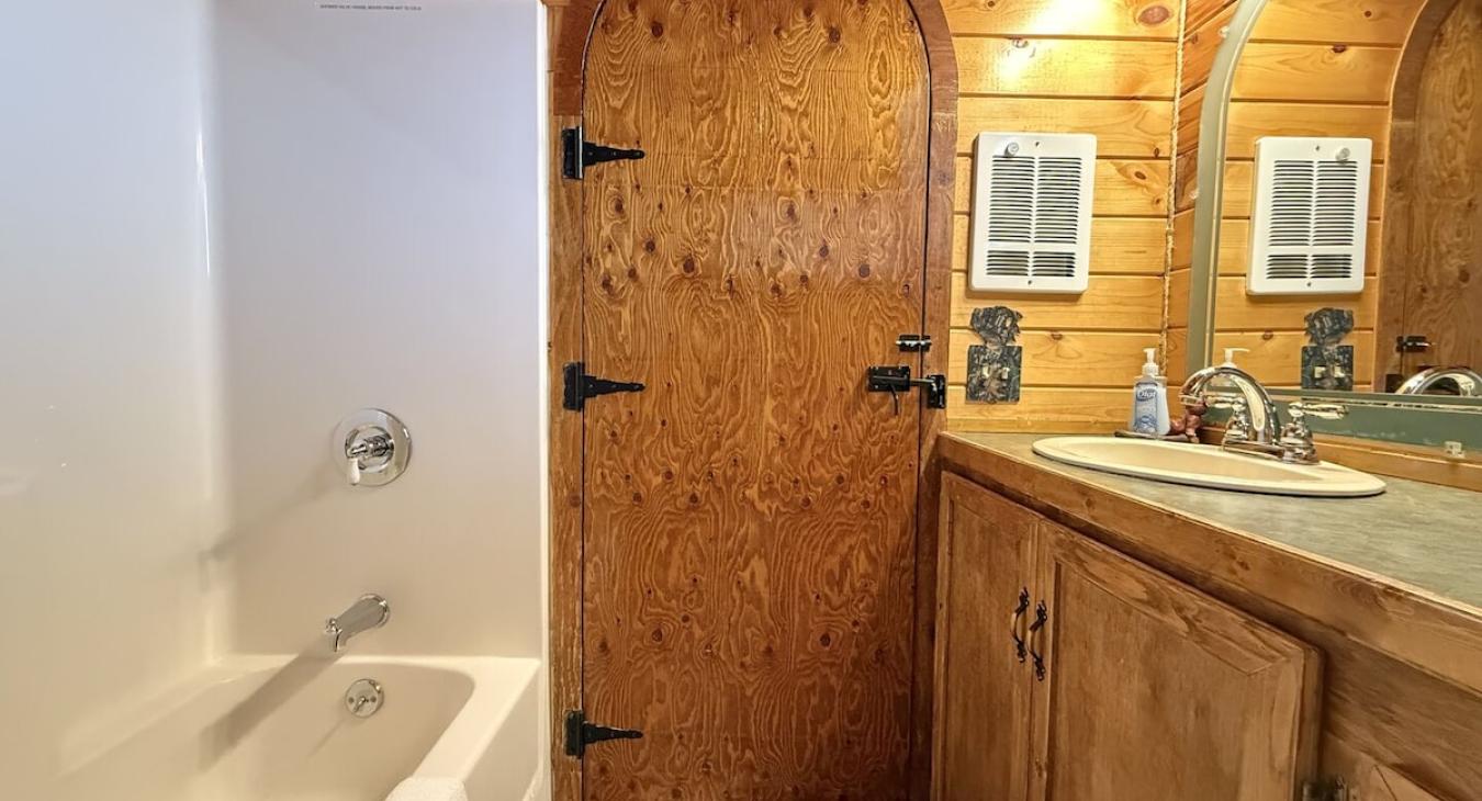 Main level full bathroom with shower, toilet, and sink vanity.