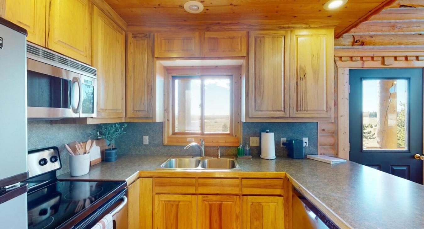 The kitchen is equipped with stainless steel appliances, cookware, pots and pans, dishes, and basic cooking essentials.