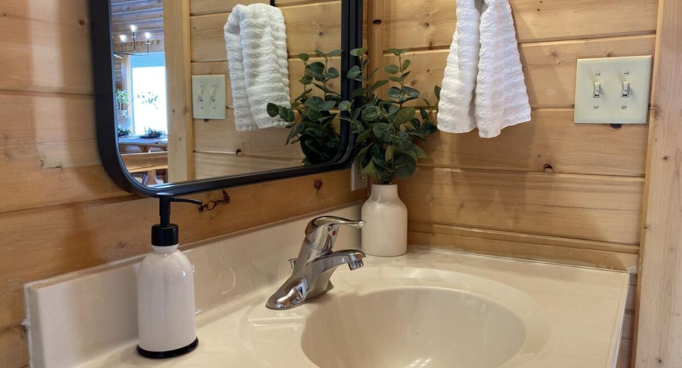 Main floor bathroom with a shower tub combo, toilet, and sink vanity.
