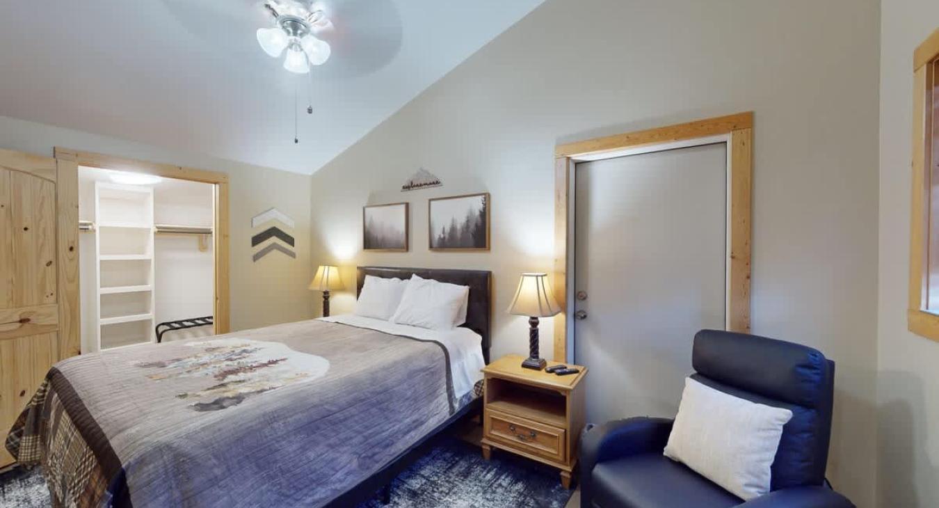 Second bedroom with a queen size bed, seating, and closet.