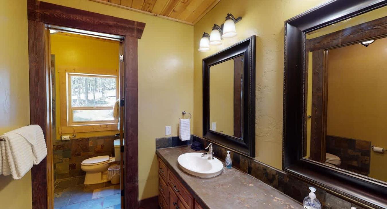 Upstairs shared bathroom equipped with shower/tub, toilet, and double sink.